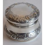 An early-20th century white-metal (marked sterling) circular box and cover decorated repoussé