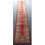 A hand-knotted Afghan Kazak-style runner; central red ground rectangle surrounded by three