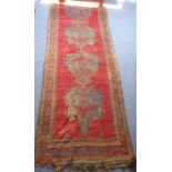 A hand-knotted Persian Senneh-style runner four shaped blue designs against a red ground and orange,