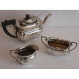 A three-piece hallmarked silver tea service comprising teapot, two-handled sugar and milk jug,