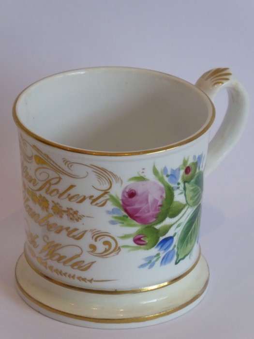 A Welsh pottery 18th century Christening mug with painted flowers and gilt inscription 'Kyffin