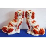 A large pair of 19th century Staffordshire pottery spaniels, hand-gilded and decorated with red-