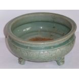 A celadon tripod censer, 15th century; the bun body crisply moulded in low relief with stylised