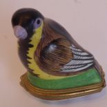 A 19th century gilt-metal mounted porcelain patch box modelled as a small bird, the interior of