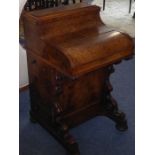 A mid-19th century rise-and-fall piano-top walnut davenport; the rise-and-fall stationery section