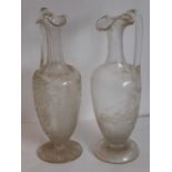 Two similar 19th century clear-glass wine jugs of slender form; the first delicately engraved with