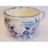 An early 19th century pottery bowl, blue transfer-decorated with figures outside a country