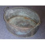 A large and heavy deeply patinated two-handled copper tub of oval form, 66cm wide (including