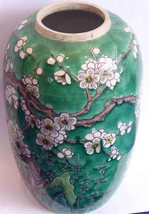 An early 20th century Japanese pottery vase decorated with birds amongst prunus blossom against a
