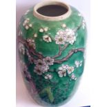 An early 20th century Japanese pottery vase decorated with birds amongst prunus blossom against a