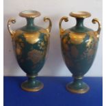 A pair of Edwardian two-handled ceramic vases gilt-decorated with various flowers, leaves etc.