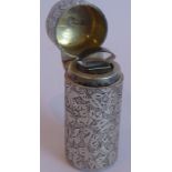 A hallmarked silver scent bottle with hinged cover, the whole profusely engraved with foliate-