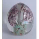 A 19th century oval paperweight decorated internally with three fungus-like shapes emanating from