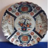 A large late 19th century Japanese porcelain charger, scalloped edge and hand-decorated in the Imari