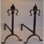 A large pair of hand-wrought-iron andirons, the pointed terminals modelled as fleur-de-lys (61cm