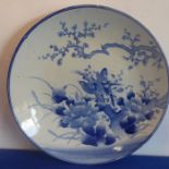 A large late 19th century Japanese porcelain charger hand-decorated in underglaze blue with exotic