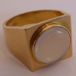 A gentleman's heavy yellow-metal ring (marked 750); centrally set with a circular moonstone and