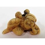 19th century ivory netsuke of a reclining sape with a monkey on his back