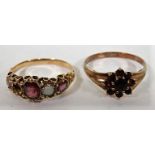 A gold and red stone flower ring with faded hallmarks together with an amethyst and opal ring, on an