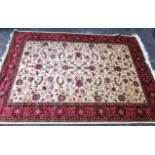 A new silk, wool and cotton rug with a cream and gold ground with a red border, decorated with