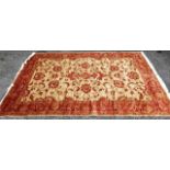 A new silk, wool and cotton rug with a red border and a central cream rectangular panel, decorated