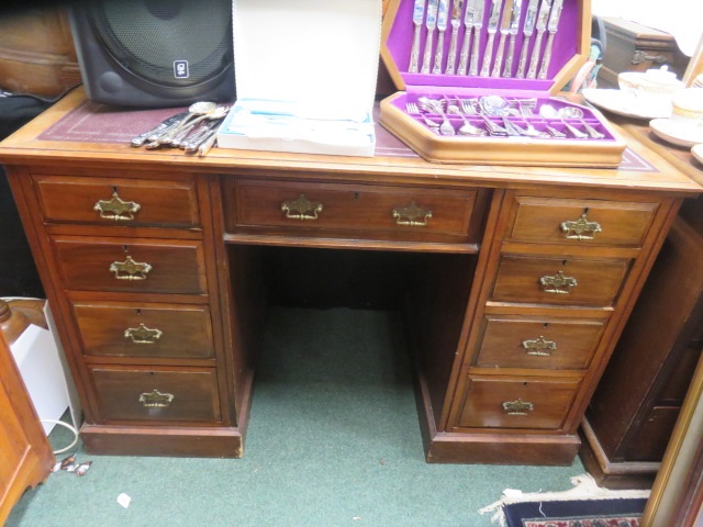 Mahogany pedestal desk, with central door, flanked by four graduating drawers on each side with