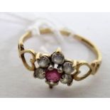 A marked 9ct gold pink sapphire and white stone flower ring, with open work hearts for the