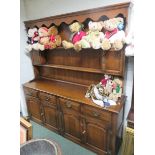 A modern stained oak dresser with scalloped frieze to top, two shelves and two small doors on second