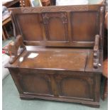 A 1930's oak hall monk's bench with lifting lid for storage and carved lion arm rests 97 x 95 x 42