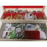 A jewellery box containing brooches and over fifty matched pairs of earrings to include a pair of