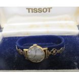 An Tissot ladies gold cased (tested) wristwatch with a marked 9.375 gold fancy strap, in original