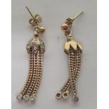 A pair of marked 375 gold and diamond dangle drop earrings, with each earring set with nine small
