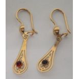 A pair of unmarked 14ct gold (tested) long openwork earrings, each set with a small round cabochon