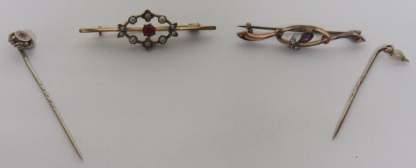 A rose gold/gilt stick pin star set with pink paste, together with a yellow metal stick pin set with