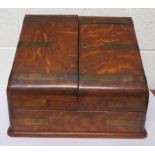An oak desk stationary box, the two doors each with brass inlay open to reveal two ink wells (both