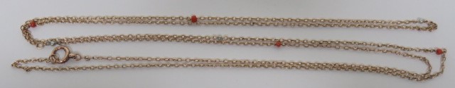 An unmarked yellow metal long necklace, with coral and seed pearl spacers, the fine belcher chain