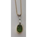 A faceted oval green garnet pendant in an unmarked gold (tested) surround, on a marked 750 fine
