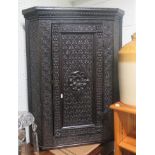 Late Victorian dark oak carved corner cabinet with carved flower to the centre, 92cm x 72cm