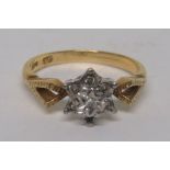 A marked 18ct gold illusion set diamond ring in a platinum flower, with a yellow gold shank, and