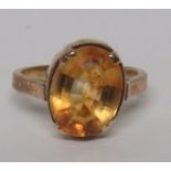 An oval faceted orange citrine cocktail ring, on an unmarked gold (tested) shank, ring size I,