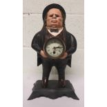 Novelty cast iron clock of a gentleman wearing a bowler hat, holding the clock face