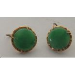 A pair of circular jade earrings with an unmarked 18ct gold (tested) surround, measuring