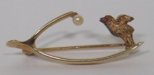 A marked 15ct gold wishbone brooch set with a seed pearl to one end, and a carved bird with pink