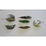 A collection of six brooches to include silver