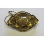 A 15ct gold brooch of ornate tiered design, with a photograph compartment to the rear, with faded