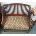 A two seater Oak settee with upholstered seat and slat back