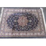 A new silk and wool rug with a blue and cream ground with a blue border and decorated with flora and