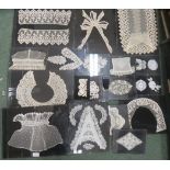 A collection of eighteen framed lace collars, samples and motifs on black mounts and clip frames -