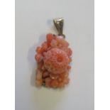 A finely carved coral brooch with a marked 375 gold back, the coral carved in floral raised
