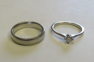 A platinum band ring marked 950 ring size J, weight 6g, together with a platinum solitaire ring,